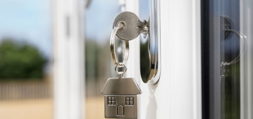 A silver key ring(with an attached house keychain) in the door
