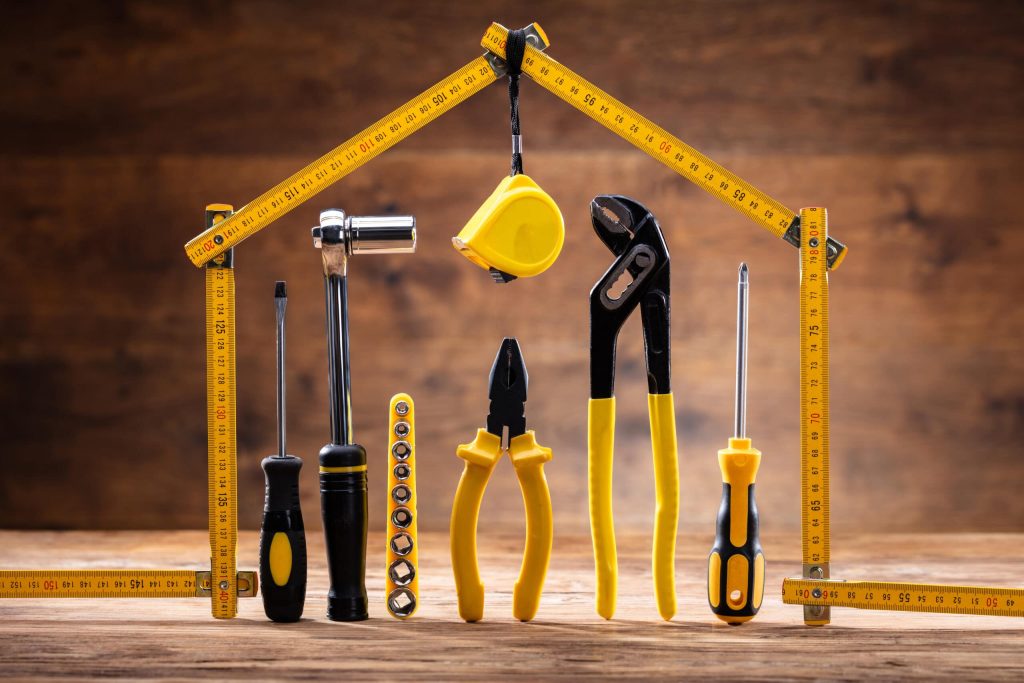 Toolkit items standing on a door, with tape measure surrounding them