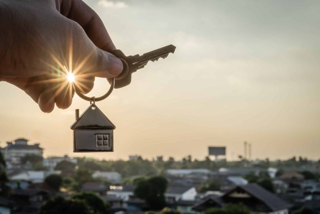 A hand holding a House model shape key, with a landscape town background