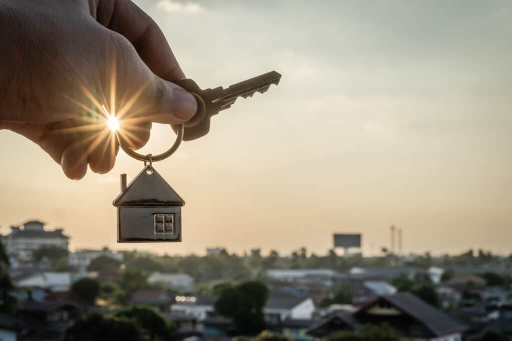 A hand holding a House model shape key, with a landscape town background